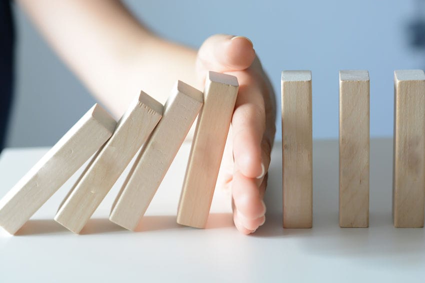 hand stopping the domino effect of addiction and intervention