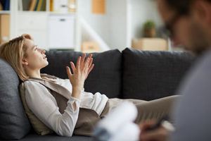 woman gesturing on couch during dialectical behavior therapy program in louisiana