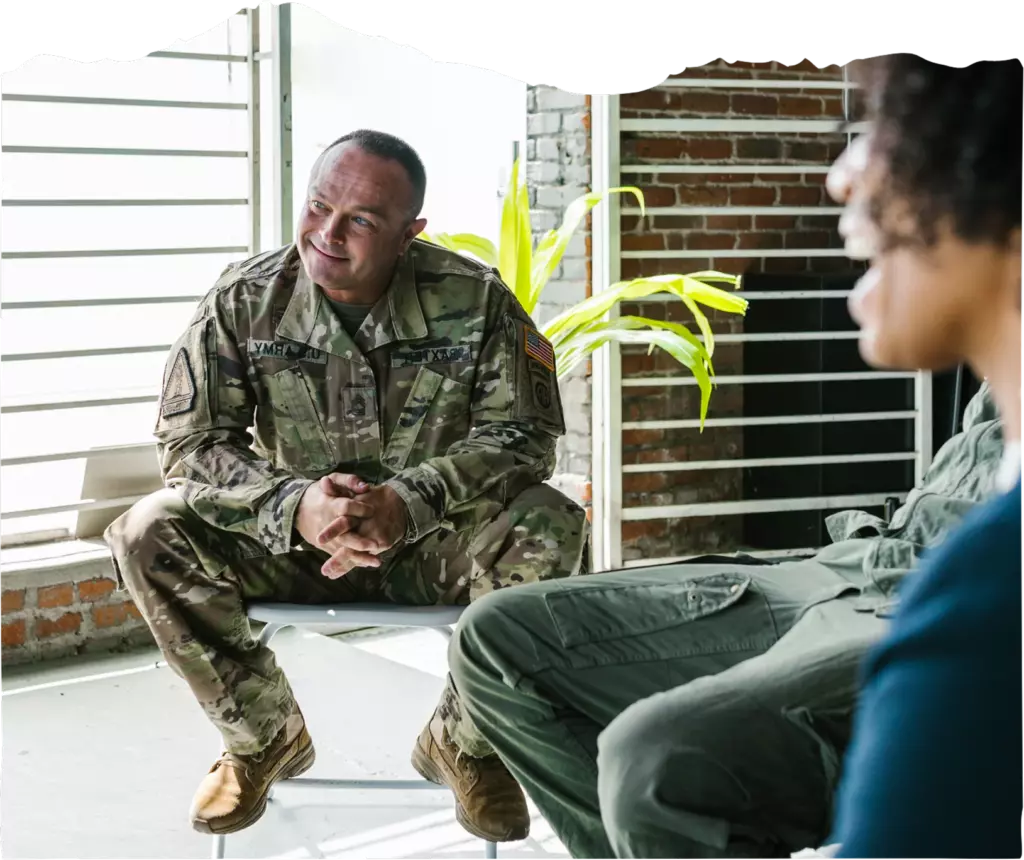 A person in military uniform listening during group therapy