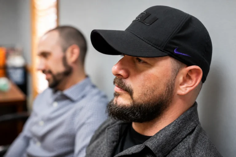Two men listening in a group therapy meeting
