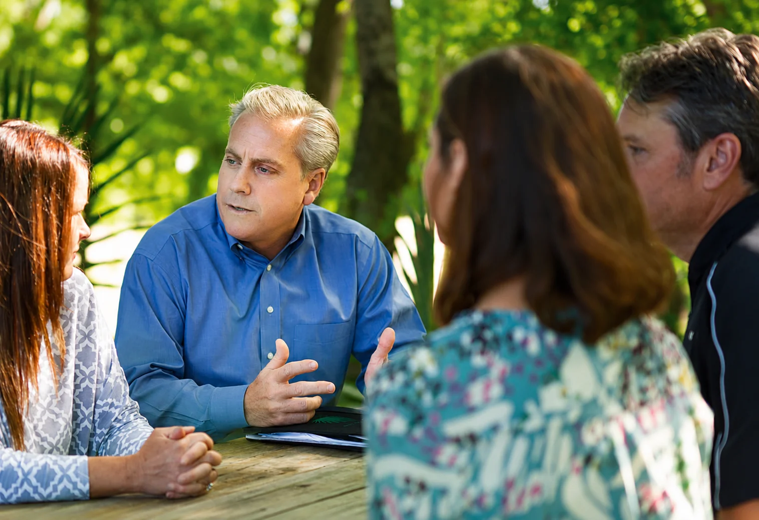 Man talking at a group meeting outdoors