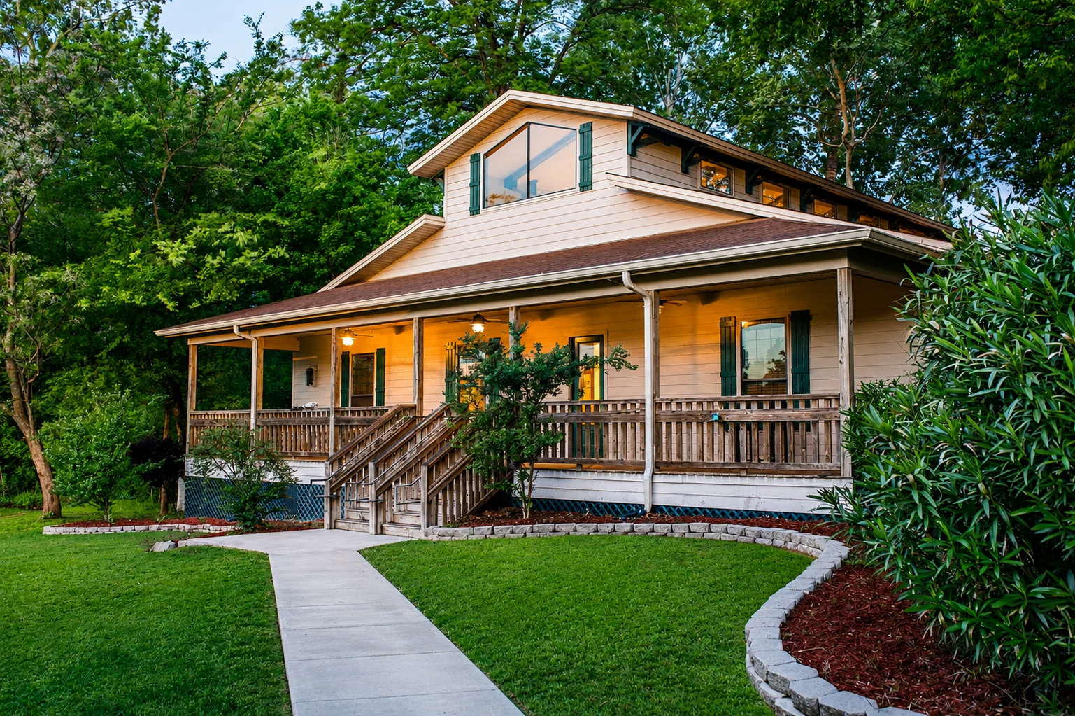 Palmetto two-story residential house with a large front porch, wooden railings, and green shutters, surrounded by trees and landscaped yard.
