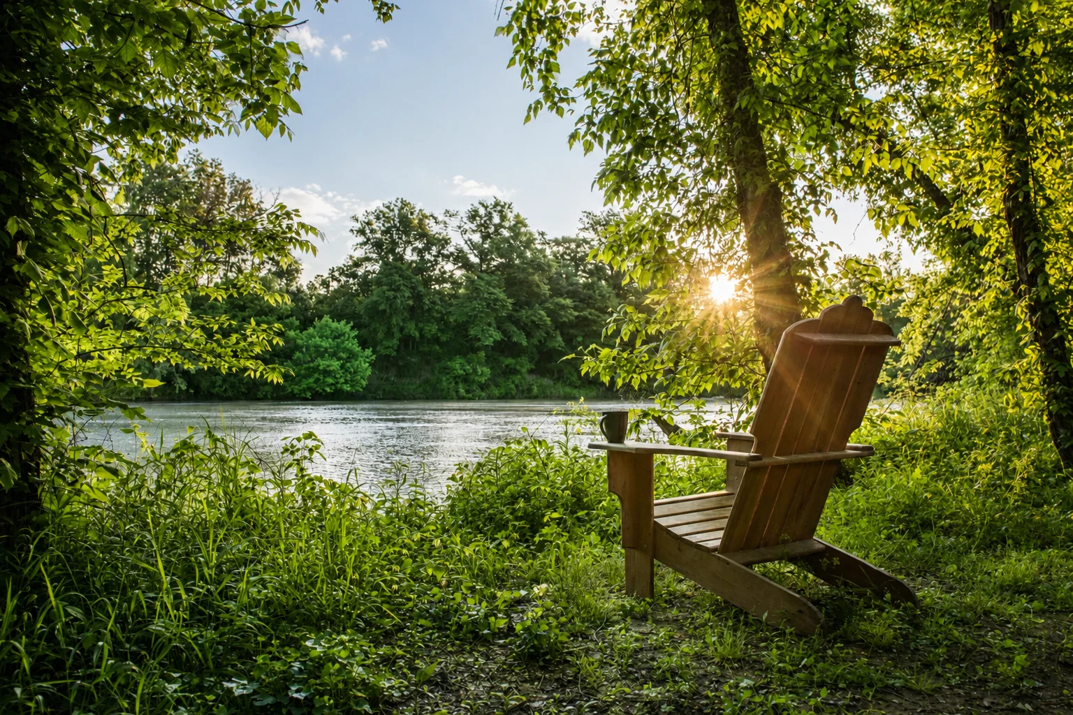 Outdoor chair facing the water and trees nearby